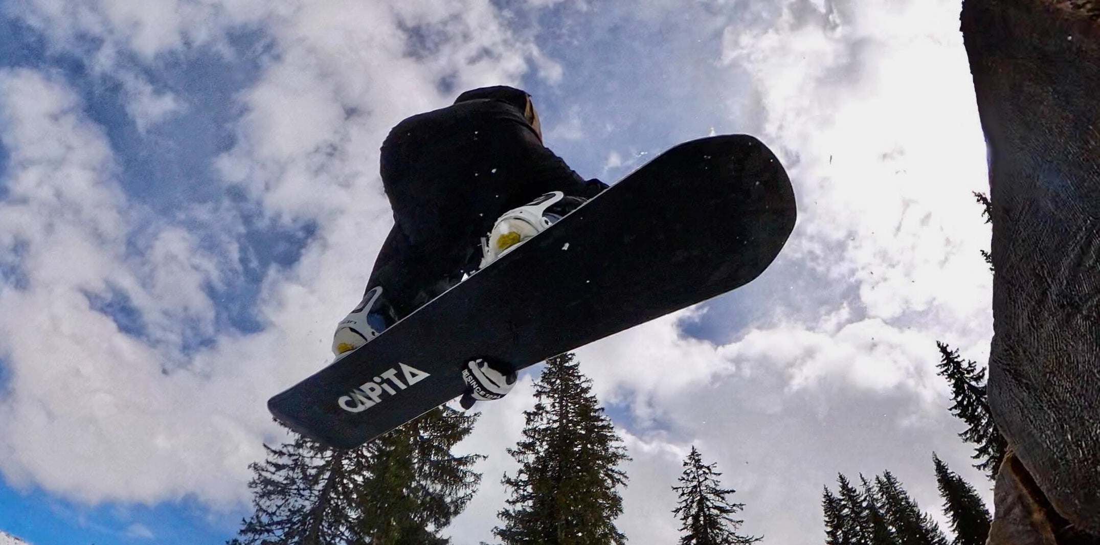 snowboarder in black mid jump