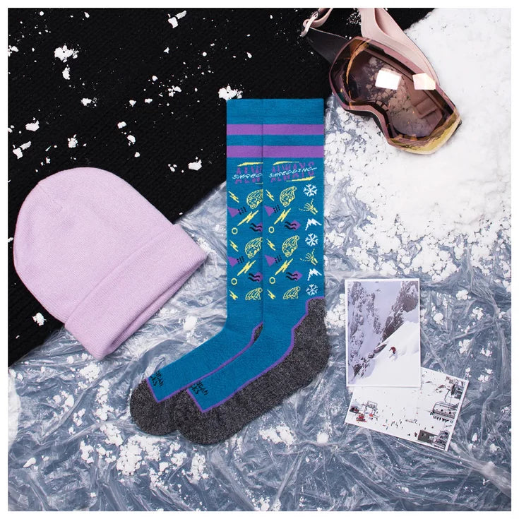 american socks snowboard socks.. blue with grey soles, purple bands around the top. multiple logos in yellow, white and purple with writing that says 'always shredding' at the top