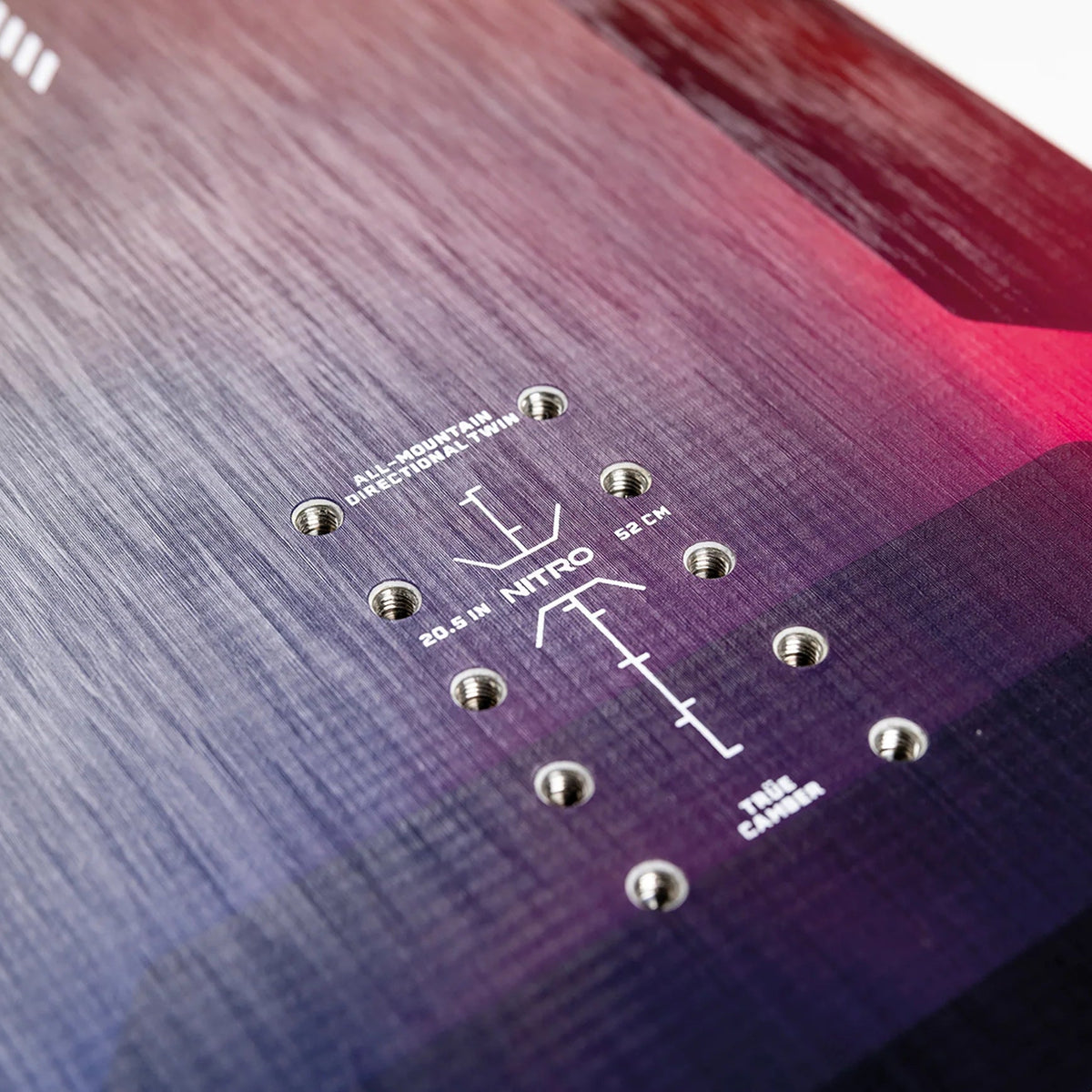 Close-up of a snowboard with brand and model information on a gradient background