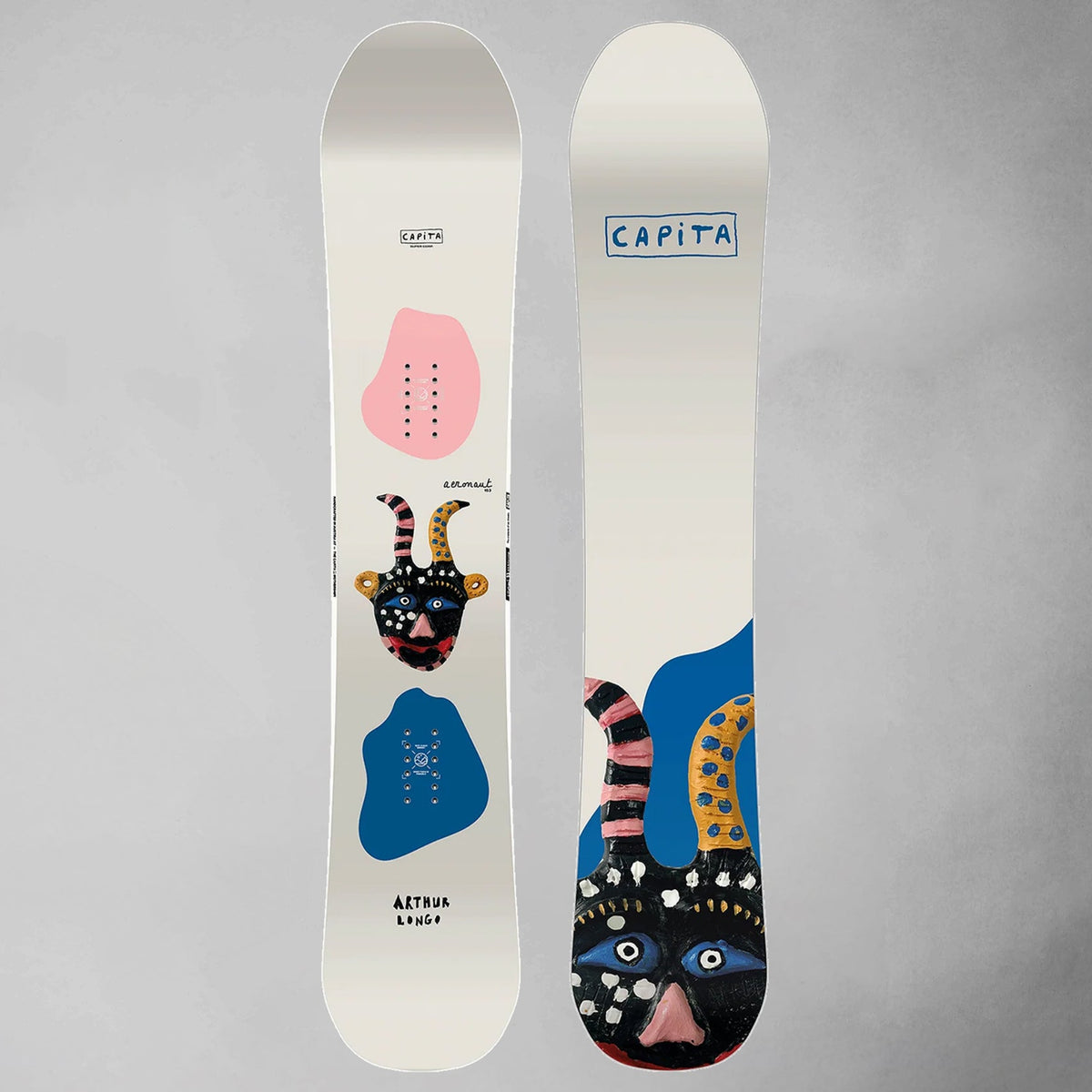 Two views of a CAPiTA Aeronaut snowboard on a neutral gray background, showing the white base with pink, blue, and black graphic designs.