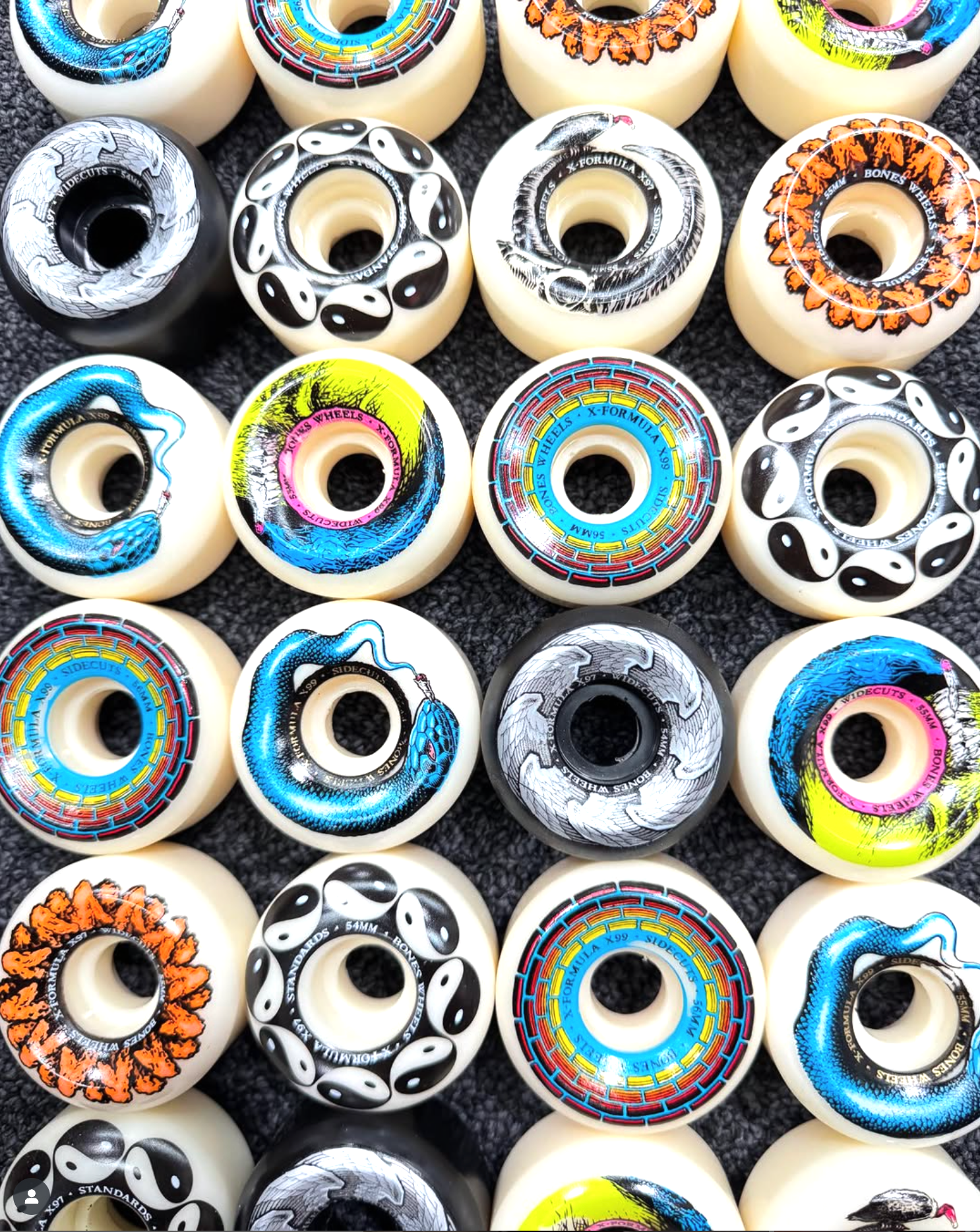 Collection of colorful skateboard wheels with various designs on a black background