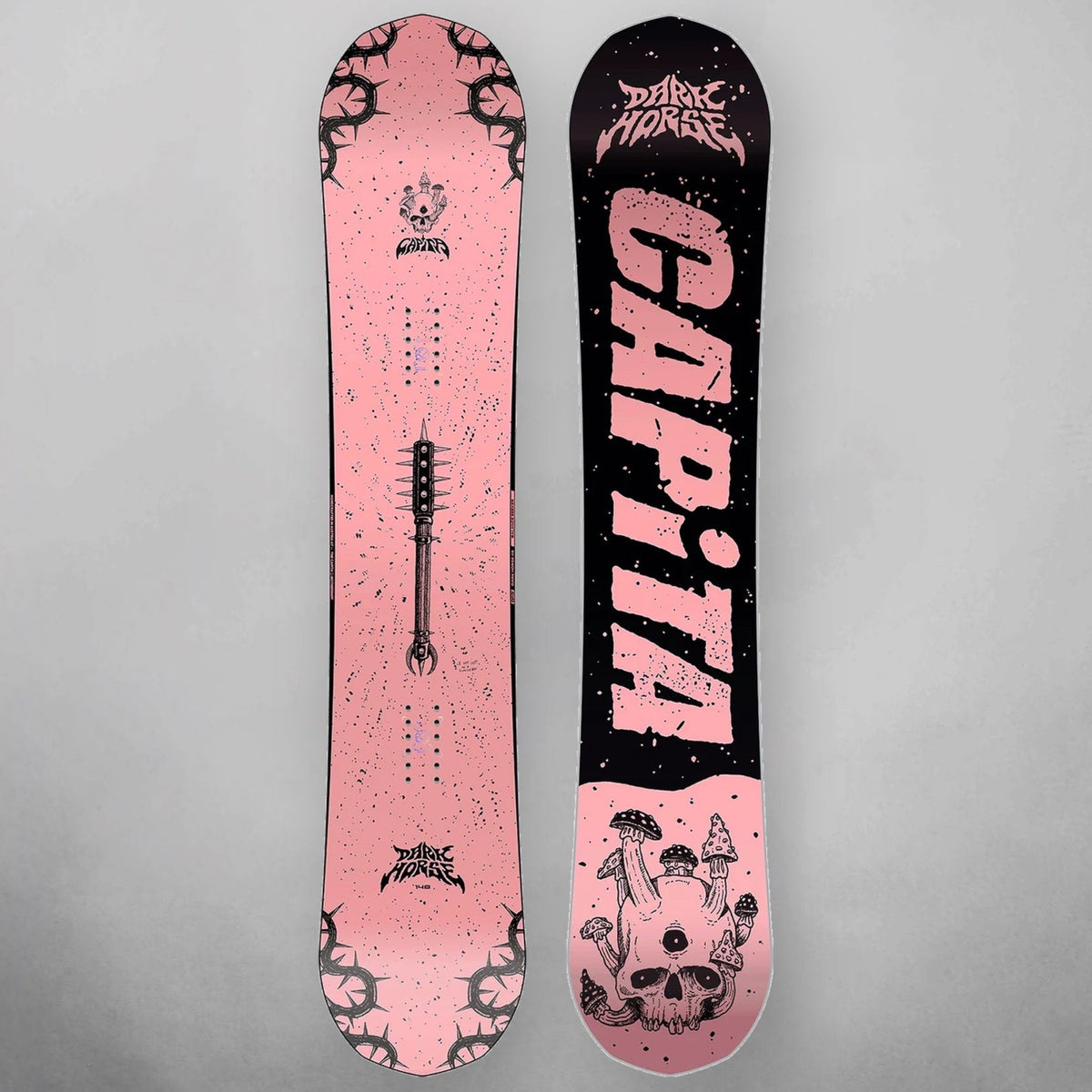 A pair of snowboards shown vertically against a neutral gray background, displaying both the pink and black sides with graphic designs, including the brand name 'CAPiTA' and 'Dark Horse'.