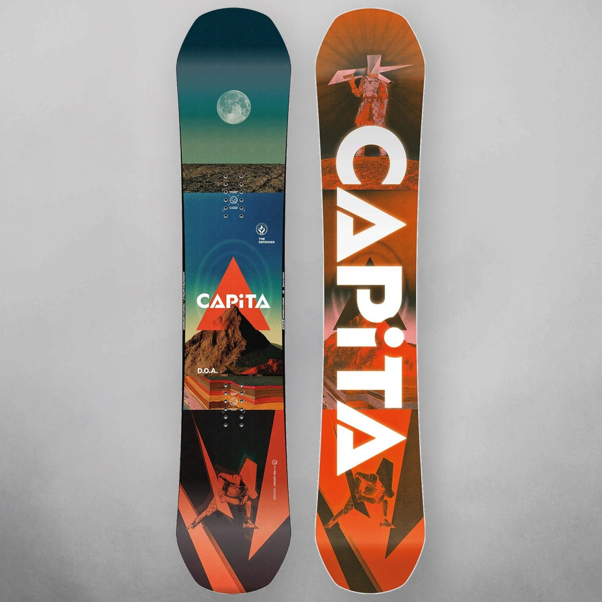 Two snowboards shown upright against a light gray background, displaying the topsides of the boards. The left board has a dark teal and black design with a mountain and moon graphic and the word 'CAPiTA' in white.