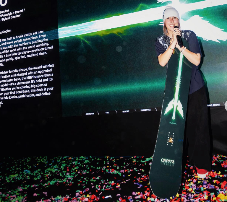 mia brookes on stage with her new capita pro model snowboard