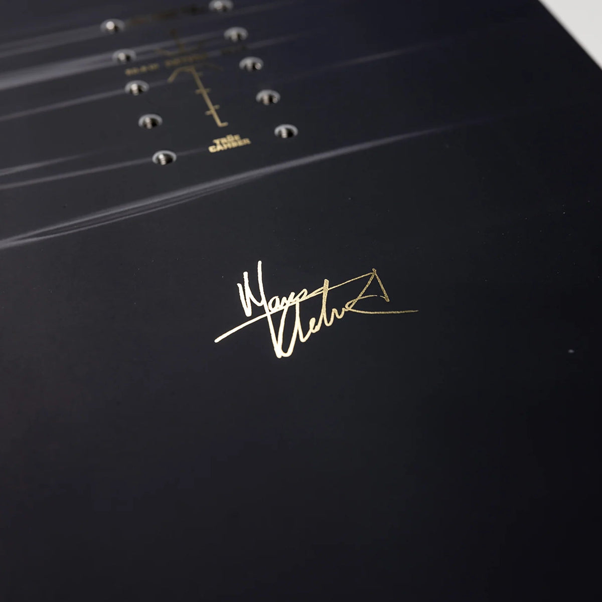 Close-up of a signature on a black surface with a white border