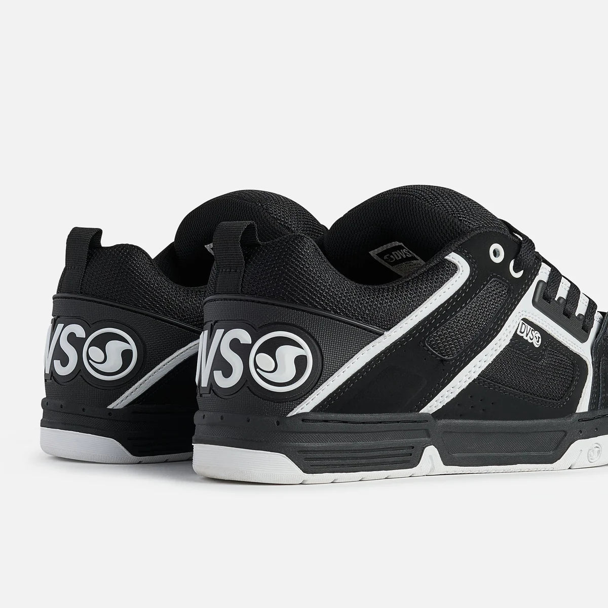 Black and white sneakers with visible branding on a light gray background