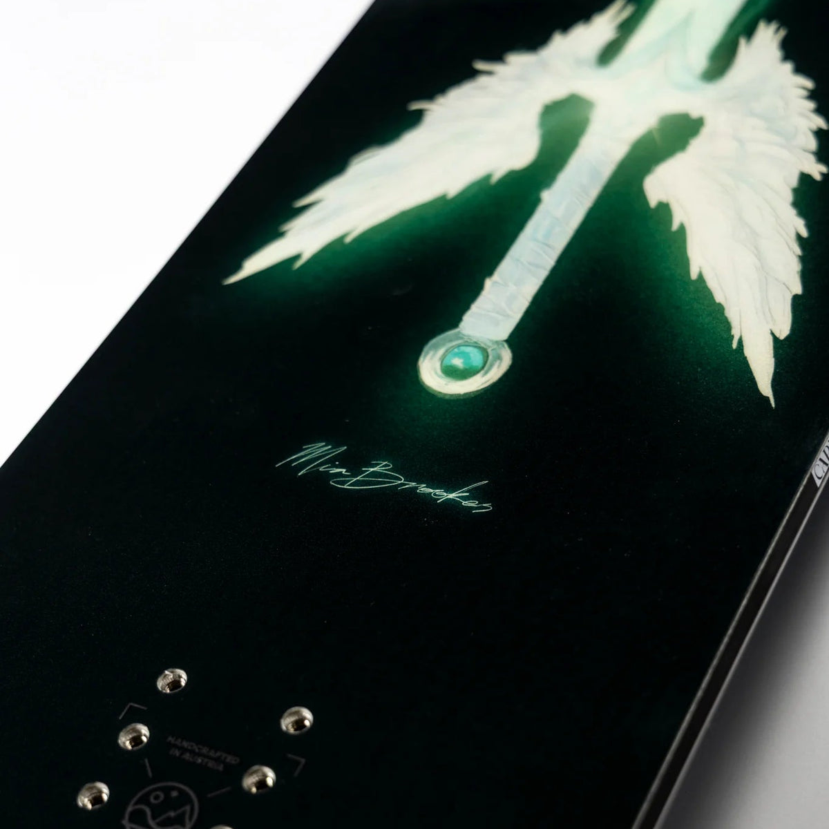Close-up of a skateboard deck with a design and brand logo on a light gray background