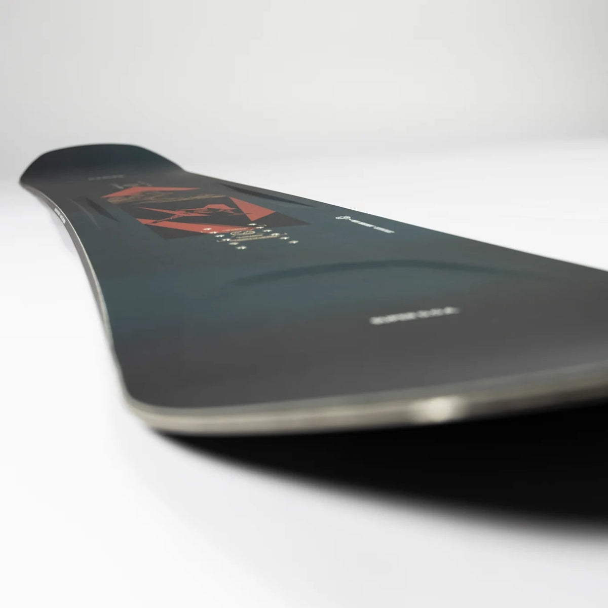 Black snowboard with branding on a white background