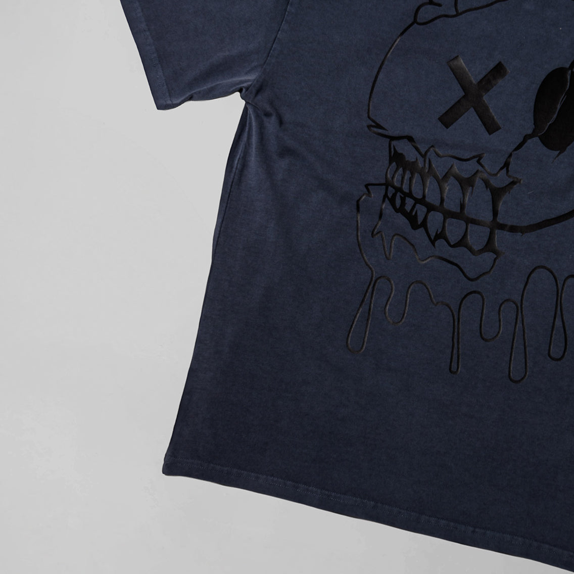 Black t-shirt with a skull design on a light gray background