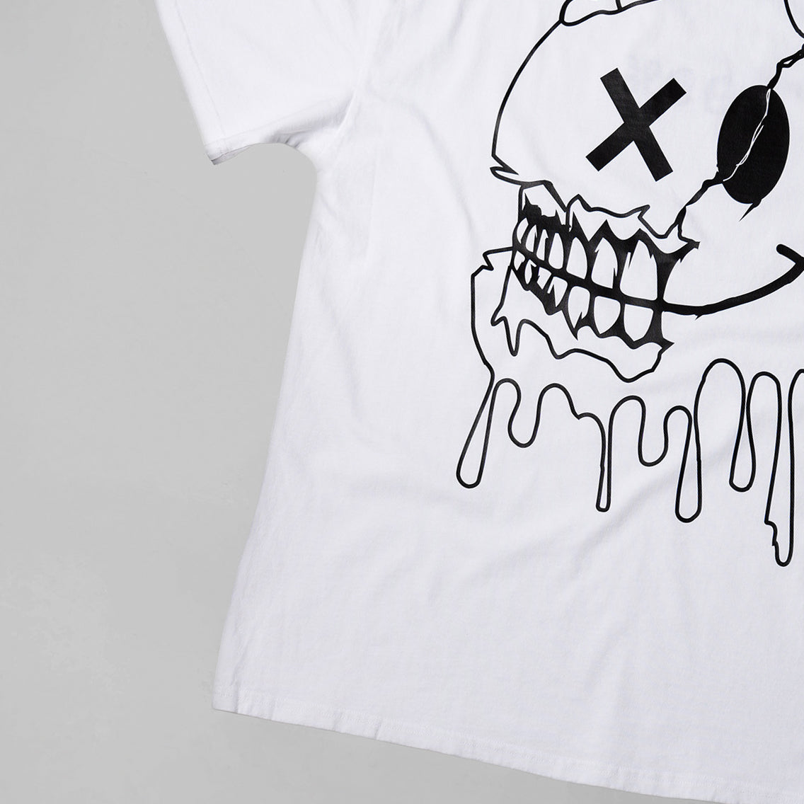 White t-shirt with a black graphic design of a skull on a gray background
