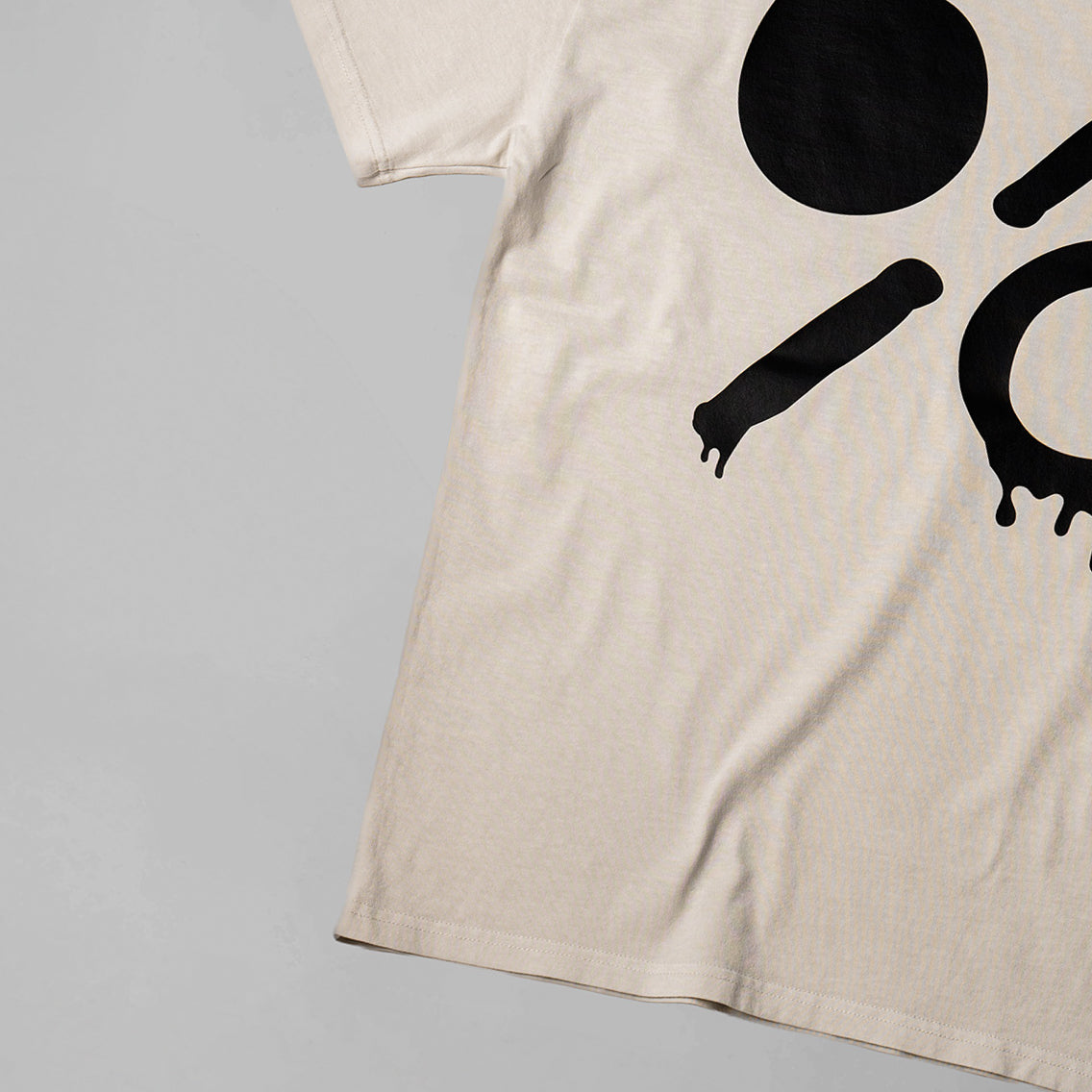 Beige t-shirt with black abstract design on a gray background